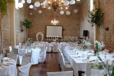 Un couple marche dans le jardin d'un château ancien entouré de verdure par une journée ensoleillée.