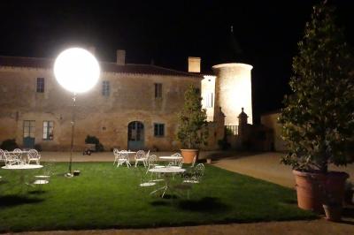 Un couple marche dans le jardin d'un château ancien entouré de verdure par une journée ensoleillée.