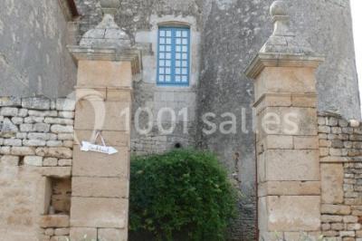 Un couple marche dans le jardin d'un château ancien entouré de verdure par une journée ensoleillée.