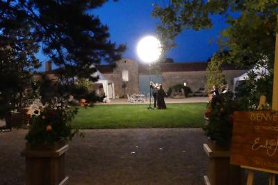 Un couple marche dans le jardin d'un château ancien entouré de verdure par une journée ensoleillée.