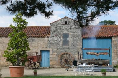Un couple marche dans le jardin d'un château ancien entouré de verdure par une journée ensoleillée.