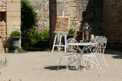 Un couple marche dans le jardin d'un château ancien entouré de verdure par une journée ensoleillée.