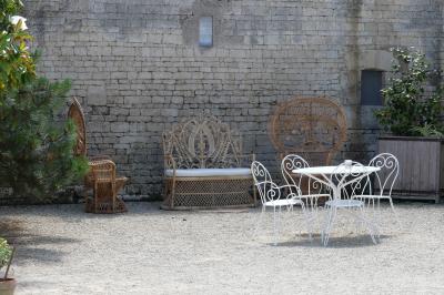 Un couple marche dans le jardin d'un château ancien entouré de verdure par une journée ensoleillée.