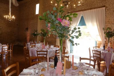 Un couple marche dans le jardin d'un château ancien entouré de verdure par une journée ensoleillée.