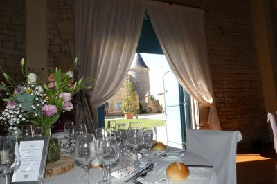 Un couple marche dans le jardin d'un château ancien entouré de verdure par une journée ensoleillée.