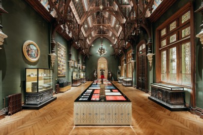 Salle de réception élégante avec tables rondes dressées, décorée de statues, fresques et lustres imposants.