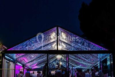 Des femmes en tenue élégante trinquent avec des verres à pied, vues en contre-plongée depuis le centre du cercle.