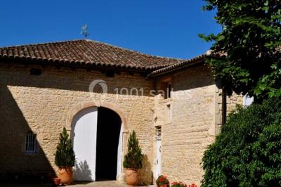 Salle de réunion avec tables disposées en U, chaises rouges, paperboards et décorations végétales.
