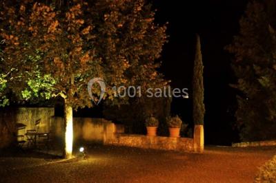 Salle de réunion avec tables disposées en U, chaises rouges, paperboards et décorations végétales.
