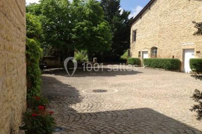 Salle de réunion avec tables disposées en U, chaises rouges, paperboards et décorations végétales.
