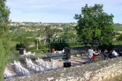 Salle de réunion avec tables disposées en U, chaises rouges, paperboards et décorations végétales.