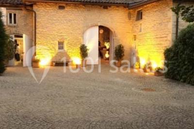 Salle de réunion avec tables disposées en U, chaises rouges, paperboards et décorations végétales.