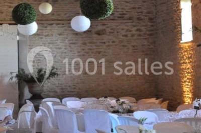 Salle de réunion avec tables disposées en U, chaises rouges, paperboards et décorations végétales.