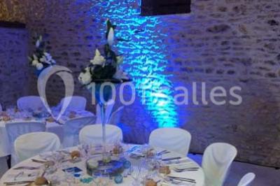 Salle de réunion avec tables disposées en U, chaises rouges, paperboards et décorations végétales.