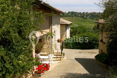 Salle de réunion avec tables disposées en U, chaises rouges, paperboards et décorations végétales.