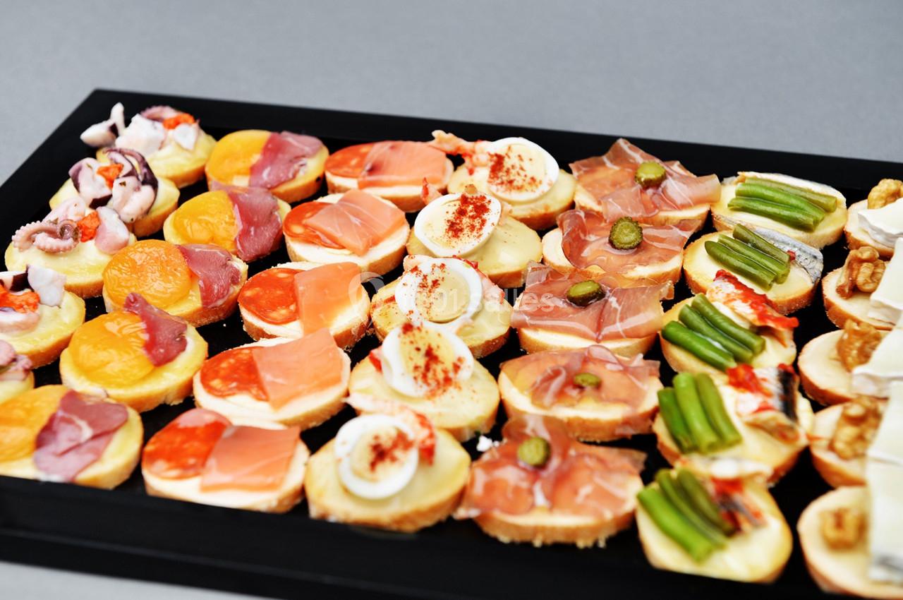 Plateau de canapés variés avec garnitures colorées comme fruits, légumes, charcuterie et fromage.