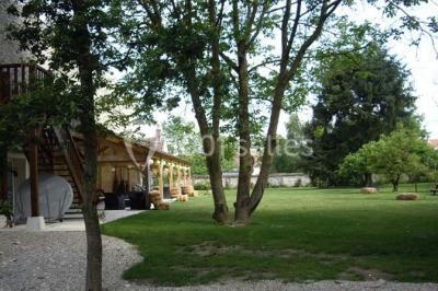 Rangée de cabines de toilettes avec portes en bois foncé, dans un espace carrelé et bien éclairé.