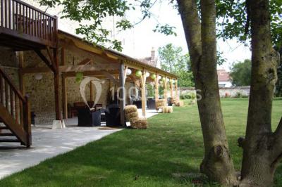 Rangée de cabines de toilettes avec portes en bois foncé, dans un espace carrelé et bien éclairé.