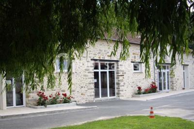 Rangée de cabines de toilettes avec portes en bois foncé, dans un espace carrelé et bien éclairé.