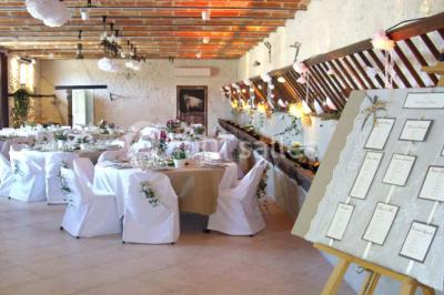Rangée de cabines de toilettes avec portes en bois foncé, dans un espace carrelé et bien éclairé.