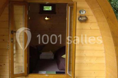Rangée de cabines de toilettes avec portes en bois foncé, dans un espace carrelé et bien éclairé.