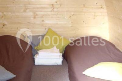 Rangée de cabines de toilettes avec portes en bois foncé, dans un espace carrelé et bien éclairé.