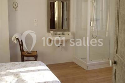 Rangée de cabines de toilettes avec portes en bois foncé, dans un espace carrelé et bien éclairé.