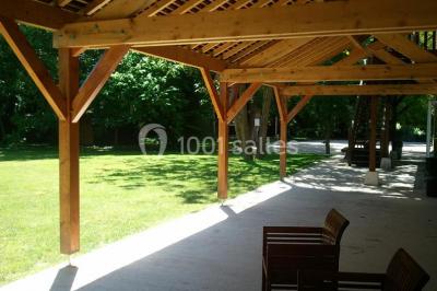 Rangée de cabines de toilettes avec portes en bois foncé, dans un espace carrelé et bien éclairé.