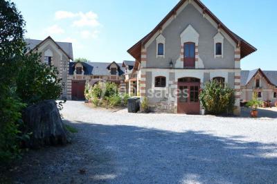 Chambre avec lit double, armoire en bois, canapé et tapis, murs en pierre et plafond avec poutres apparentes.