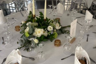 Chambre avec lit double, armoire en bois, canapé et tapis, murs en pierre et plafond avec poutres apparentes.