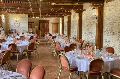 Groupe de personnes assises en cercle dans un jardin verdoyant, vu depuis une fenêtre d'un bâtiment en briques.