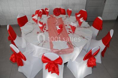 Deux femmes en robes traditionnelles violettes ornées de bijoux, posant devant un fond clair avec un fauteuil argenté.