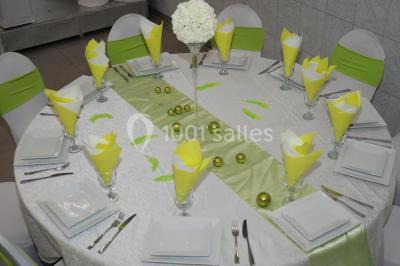 Deux femmes en robes traditionnelles violettes ornées de bijoux, posant devant un fond clair avec un fauteuil argenté.