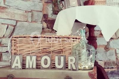 Un couple en tenue de mariage se regarde sous une pergola illuminée de guirlandes lumineuses.