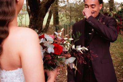 Un couple en tenue de mariage se regarde sous une pergola illuminée de guirlandes lumineuses.