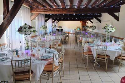 Terrasse extérieure avec tables dressées, parasols blancs, lampadaire et bâtiment à colombages en arrière-plan.