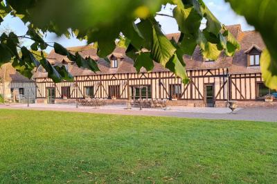 Terrasse extérieure avec tables dressées, parasols blancs, lampadaire et bâtiment à colombages en arrière-plan.