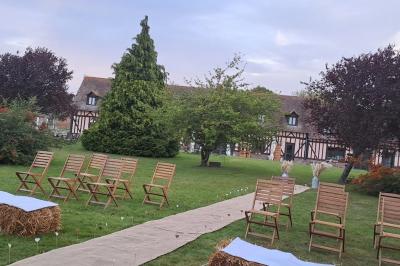 Terrasse extérieure avec tables dressées, parasols blancs, lampadaire et bâtiment à colombages en arrière-plan.