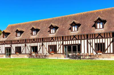 Terrasse extérieure avec tables dressées, parasols blancs, lampadaire et bâtiment à colombages en arrière-plan.