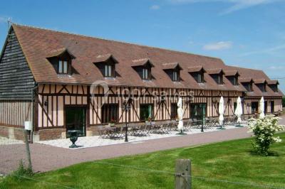 Terrasse extérieure avec tables dressées, parasols blancs, lampadaire et bâtiment à colombages en arrière-plan.