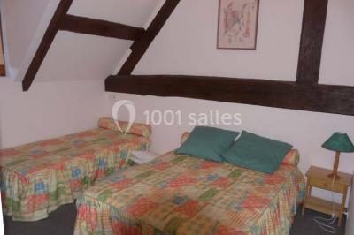 Terrasse extérieure avec tables dressées, parasols blancs, lampadaire et bâtiment à colombages en arrière-plan.