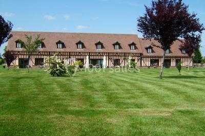 Terrasse extérieure avec tables dressées, parasols blancs, lampadaire et bâtiment à colombages en arrière-plan.