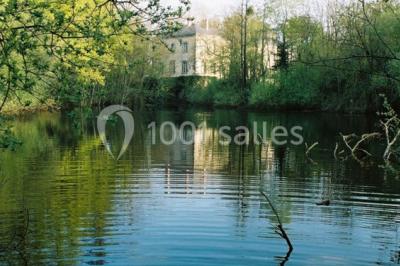 Chambre lumineuse avec un lit double, des rideaux fleuris, un lustre, des meubles classiques et des fenêtres donnant sur la…