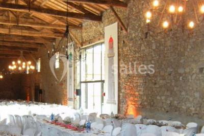 Chambre lumineuse avec un lit double, des rideaux fleuris, un lustre, des meubles classiques et des fenêtres donnant sur la…